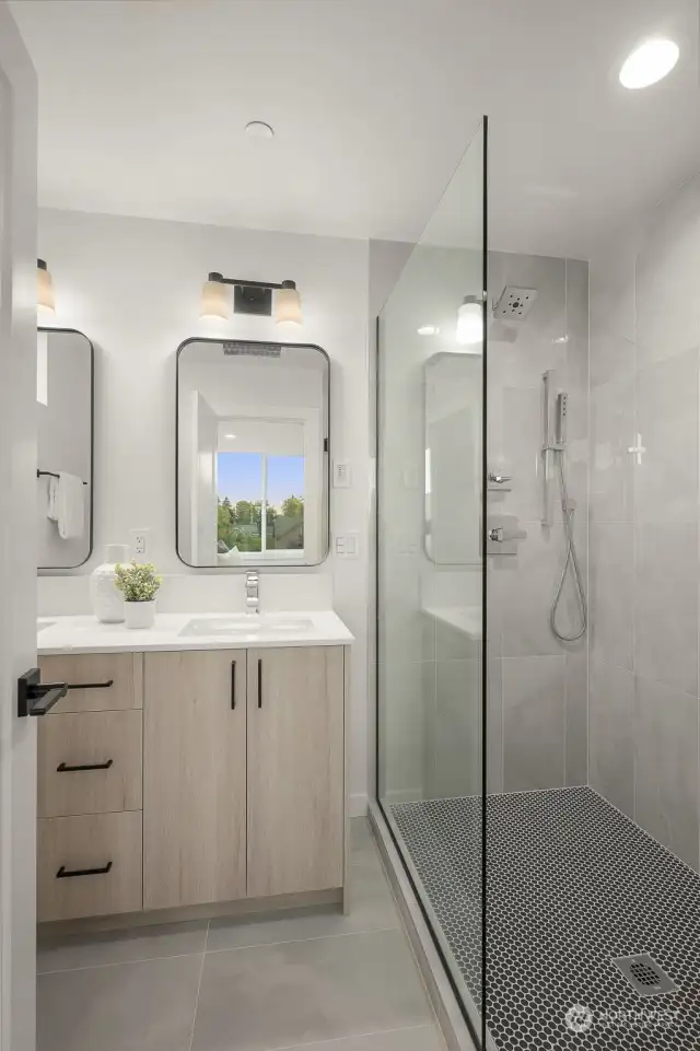 Indulge in your spa-like retreat with this glass-enclosed shower and modern bathroom design.