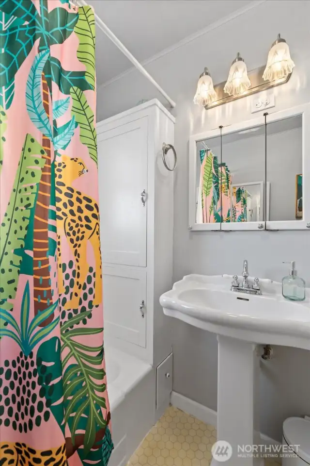 Bathroom features original vintage cabinetry.