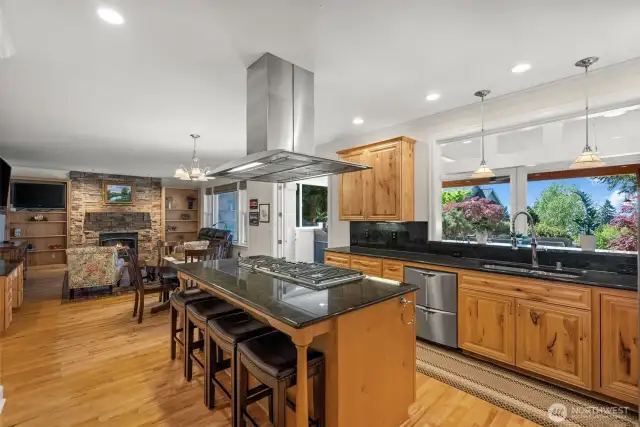 Gourmet kitchen with Wolf 6-burner propane range looks out to living room and sunroom