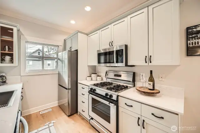 you new kitchen is completely refreshed with gorgeous cabinetry, white quartz counters, newer fridge and dishwasher, large sink and newer restaurant style faucet!