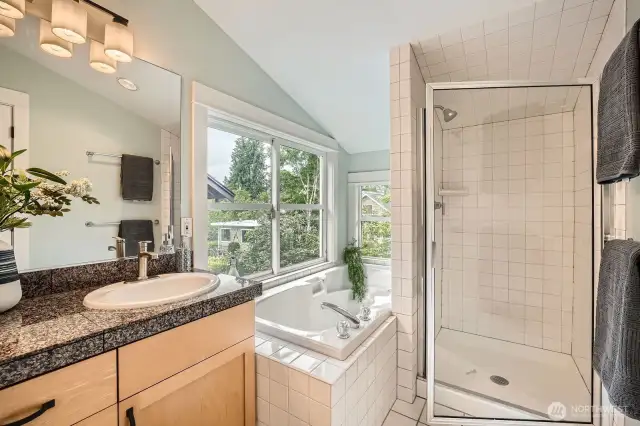 full 5 piece spay like primary bath with deep soaking tub, two vanities, and separate toilet room with door