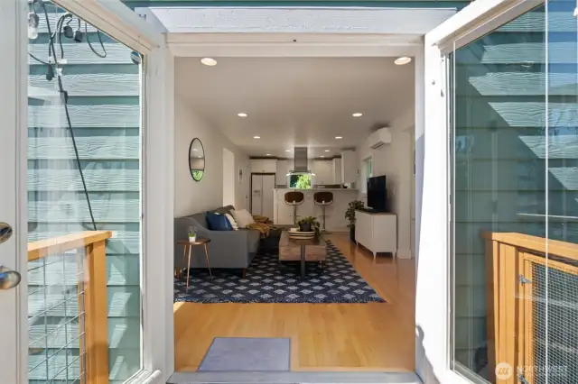 The open-concept living space offers filtered water views and easy access to the fully fenced backyard—complete with raised garden beds, established landscaping, and a spacious deck perfect for relaxing with a sea breeze and the scent of flowers in the air.
