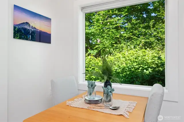Enjoy meals in this dining nook with a lush natural view.