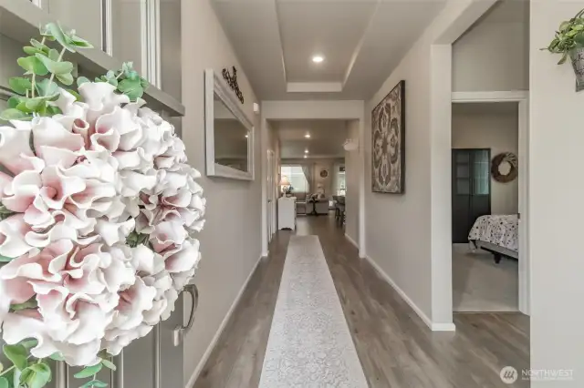 Front entry view down the hallway, with 2 bedrooms and a full bathroom on the right