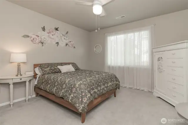 Primary bedroom with ceiling fan and natural light