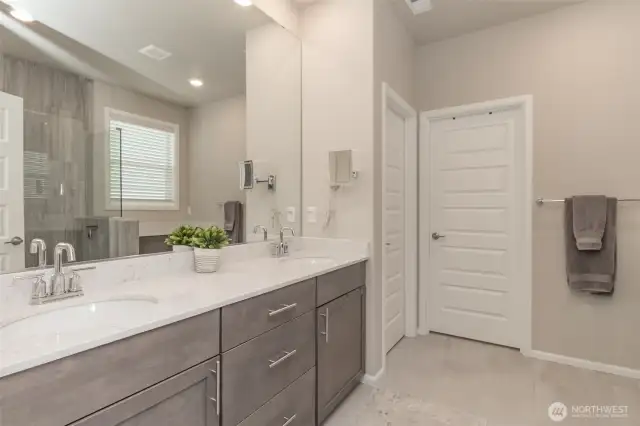 Another view of ensuite bathroom with doors to lavatory and walk-in closet