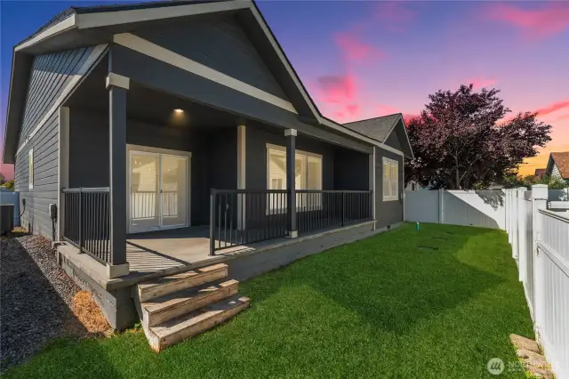 The covered rear porch invites relaxed outdoor living, perfect for enjoying warm Eastern Washington evenings. A beautifully manicured and fully fenced rear yard offers privacy, greenery, and space to unwind