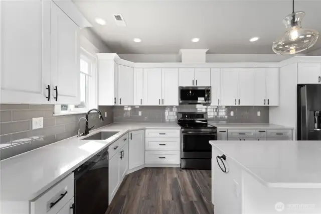 Sleek and sophisticated, this gourmet kitchen boasts high-end finishes, a large island bar and quartz countertops
