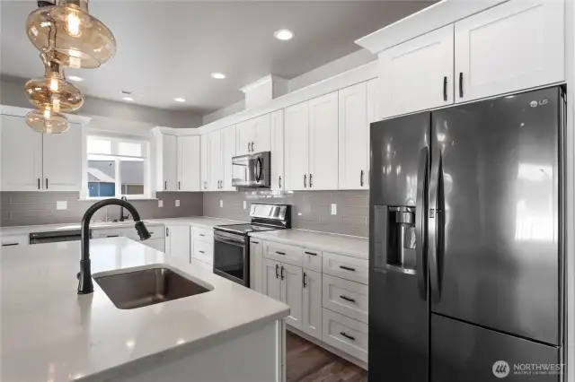 Anchored by a generous island with a stylish eating bar, this kitchen combines high-end finishes and smart design—ideal for hosting, dining, or simply enjoying the art of everyday living