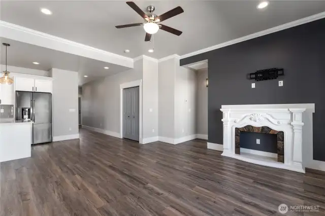 This cozy living room, bathed in natural light from large windows, seamlessly connects to the open concept floor plan—offering a perfect blend of comfort, style, and spacious flow
