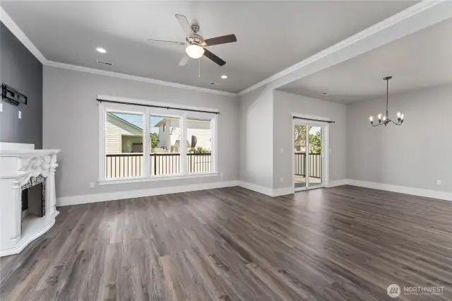 This gorgeous living room, bathed in natural light from large windows, seamlessly connects to the open concept floor plan—offering a perfect blend of comfort, style, and spacious flow