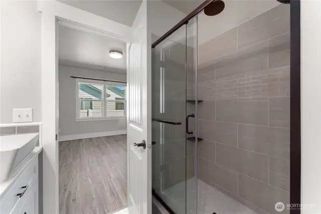 Elegant and functional, this primary en-suite features double sinks, designer finishes, a spacious walk-in closet, and a fully tiled shower for a spa-like experience