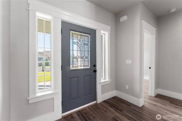A welcoming foyer illuminated by large windows, creating an open and airy first impression
