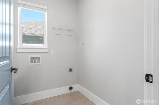 Well-lit and roomy, the utility room offers plenty of space and large windows that bring in refreshing daylight