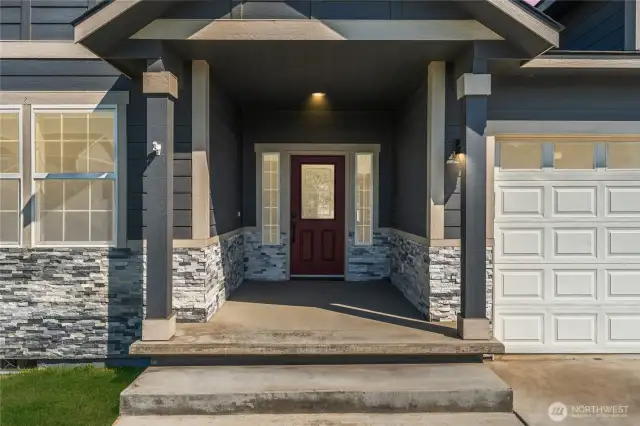 The covered front entry exudes charm and elegance, enhanced by rich stone accents and thoughtful architectural design