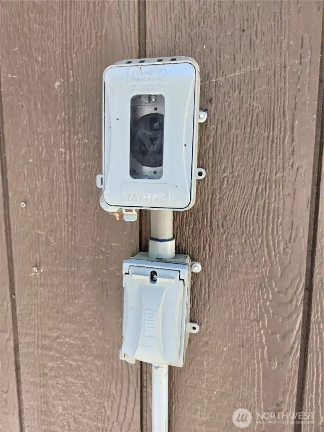 Exterior electrical hookups on back corner of cabin.