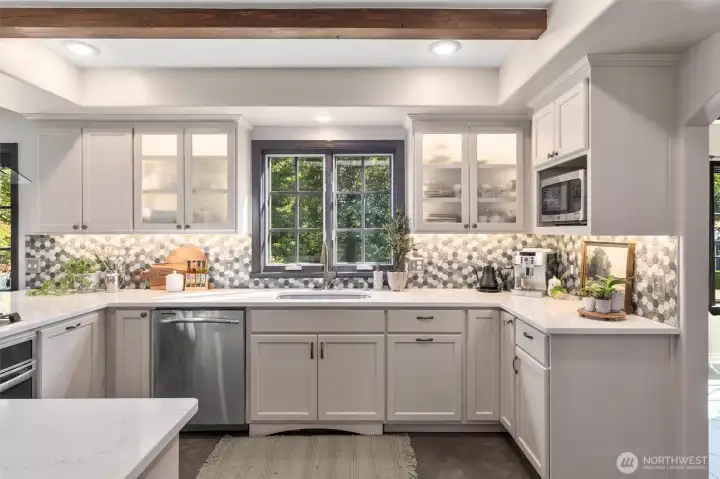 Wrapped with tile backsplash, undermount lighting and sleek quartz counters.