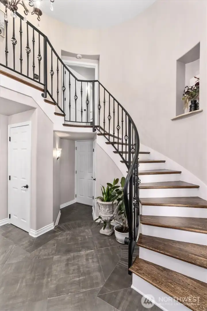Grand spiral staircase leads to upstairs bedrooms and laundry room.