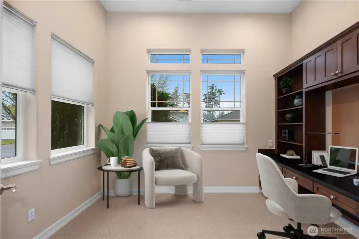 Bright and spacious den/flex space featuring custom built-in cabinets and a desk perfect for a home office, study, or creative workspace.