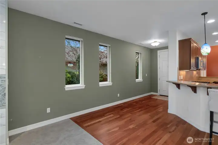 Beautiful entryway featuring hardwood floors and sunlit windows that look out onto the garden, an inviting first impression filled with natural light and charm.