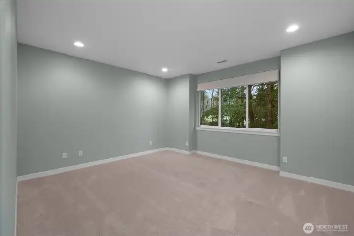 Serene primary bedroom featuring brand-new carpet with a plush memory foam pad, Roman blackout blinds, and peaceful golf course views framed by wooded privacy a perfect retreat at the end of the day.