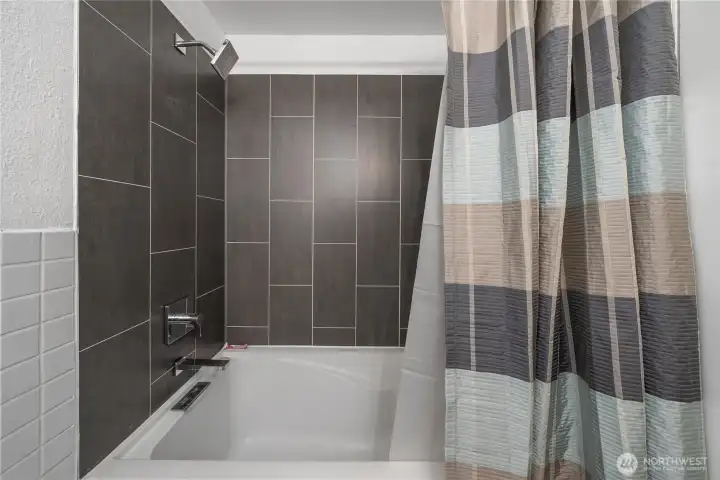 Remodeled guest bathroom shower with tub.