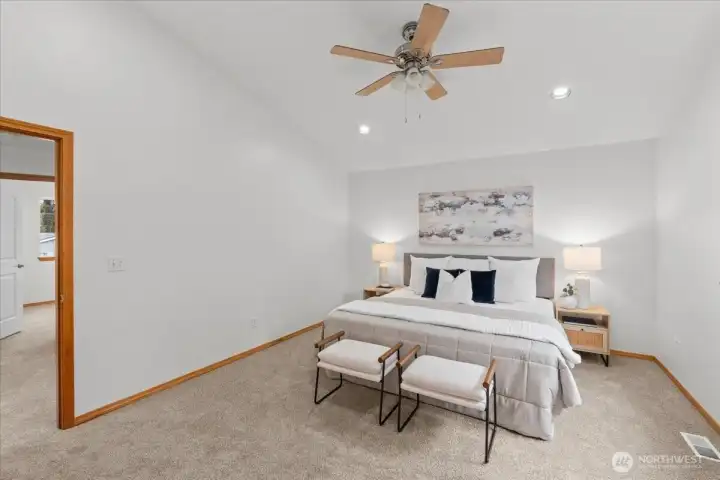 Primary bedroom with carpeted flooring, ceiling fan, and recessed lighting. Neutral finishes and generous floor space allow flexible furniture placement.