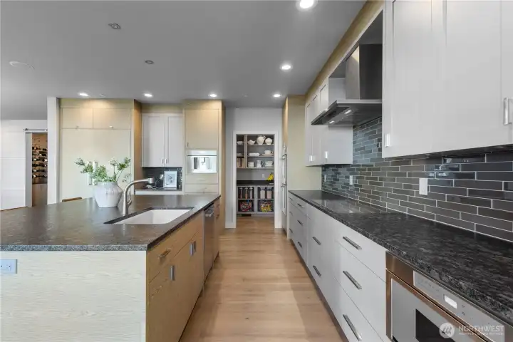 A discreet, spacious walk-in pantry ensures all your culinary essentials are organized and within reach, keeping the main kitchen pristine.