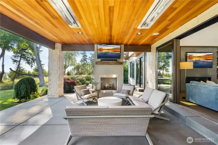 Massive sliding glass doors disappear to seamlessly merge the grand living room with the heated covered patio, doubling your entertaining space in an instant.