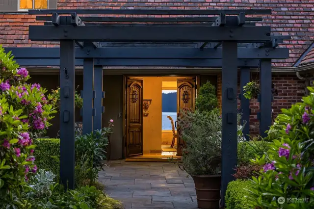Wood arbor, stone pathway and wood double doors welcome guests inside. One can catch a glimpse of the mesmerizing views from here.