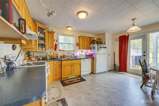 Kitchen with eat in dining, oak cabinets, dishwasher and French doors to the back yard.