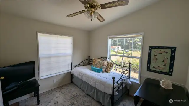 Light filled den with ceiling fan.