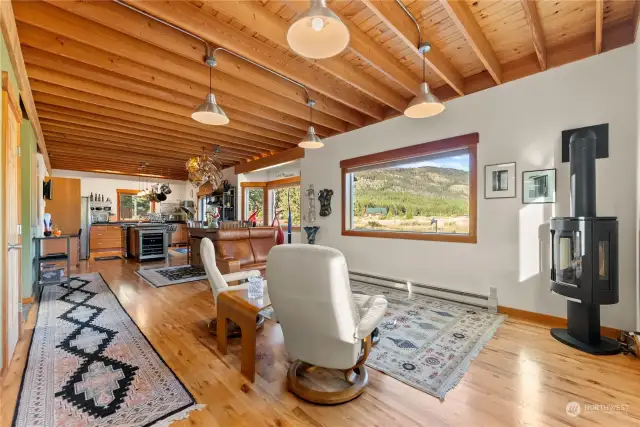 Gather here in this great room with flawless hard-wood floors and open 9ft ceiling inviting the views and natural light in. Mountain views from all windows. Glowing propane fireplace soothes you each Winter night.