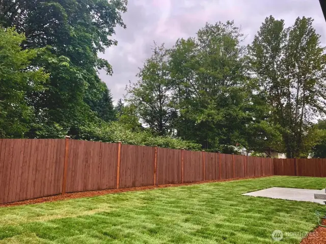 Photo is of actual yard and home under construction. See site agent for details. Large private backyard with trees in backdrop.  Large corner lot!