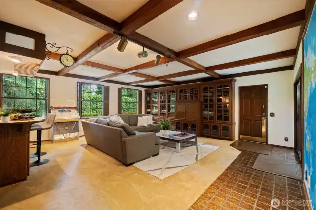 Bonus room with build in bar has beautiful, timeless box beam ceiling, built-in cabinets, a beverage fridge and leads to the breezeway.