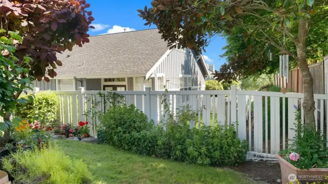 Fully fenced yard full of beautiful plantings