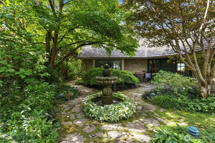 Set on a beautifully landscaped 15,718 square foot lot, the grounds feel like a private arboretum, with mature plantings, manicured garden paths, and a custom vintage playhouse.