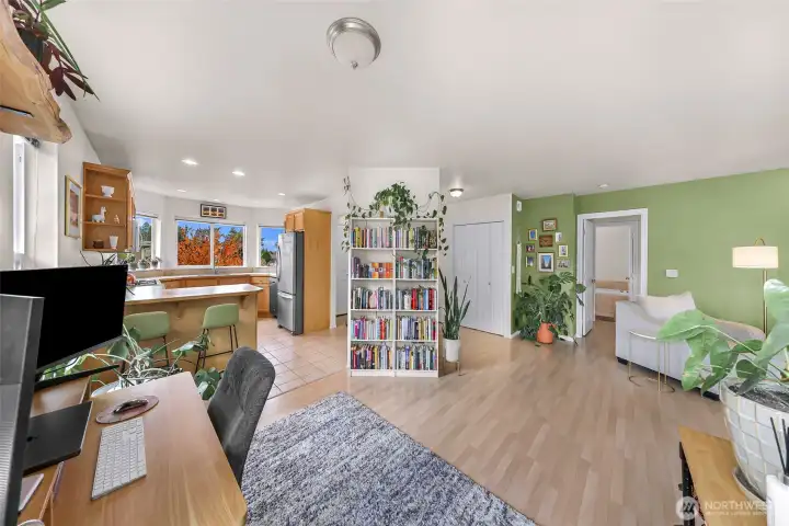 Looking from the office towards the kitchen on the left and the living room and primary suite off to the right.