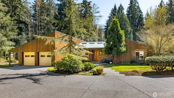 This stunning single-level home features a metal roof, real wood and stone siding, abundant light through well-placed windows and skylights, an attached garage (plus additional shop), and two primary suites.
