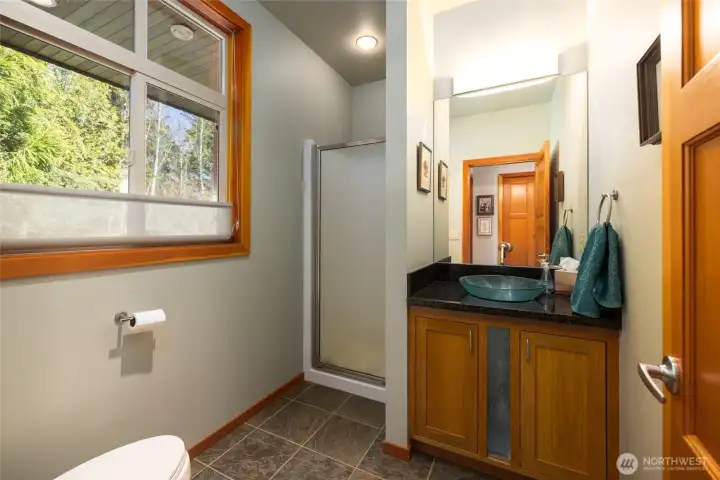 Guest bathroom, with tile floor, shower, and granite vanity w/vessel sink.