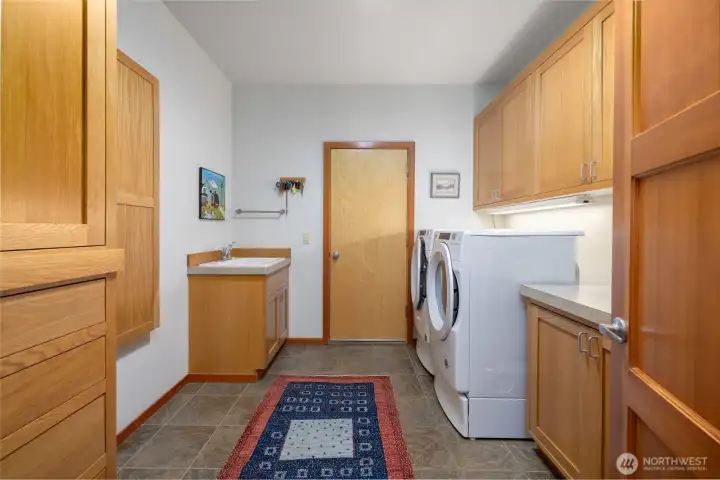 If you were going to dream of laundry rooms, this would be the one to dream about...so much storage! Utility sink.  Ironing center.  Door at back goes to the attached two car garage.