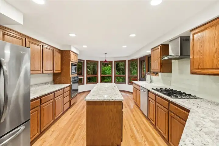 Updated kitchen with stainless steel appliances, granite counters, gas stove top and fan.