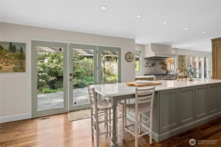 Lots of designed storage on both sides of the custom island with marble countertop.