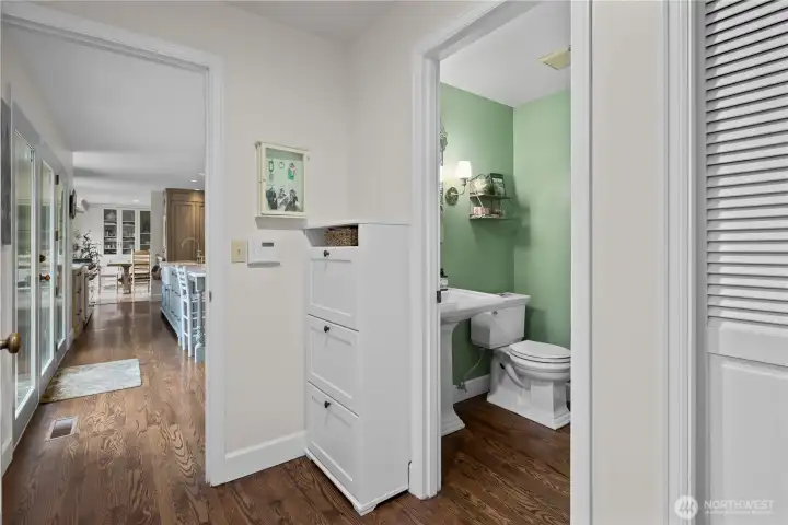 view from hallway transitioning from 3 car garage with convienetly located half bathroom.