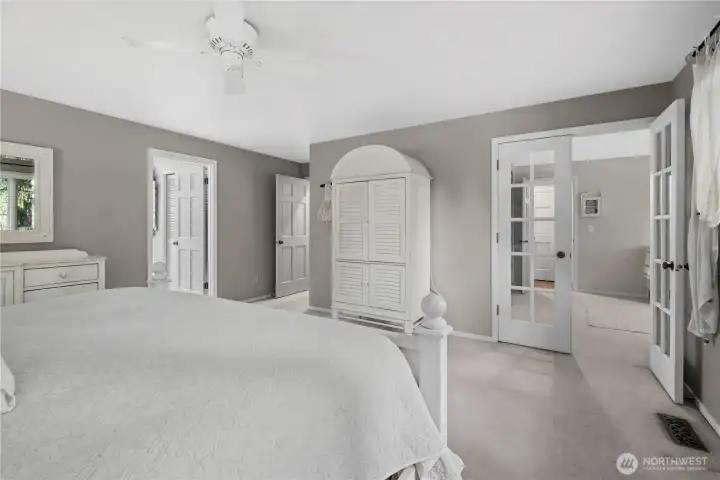 Primary suite with walk-in closet, full bathroom with dual vanities and heated floors, and entry into nursery.