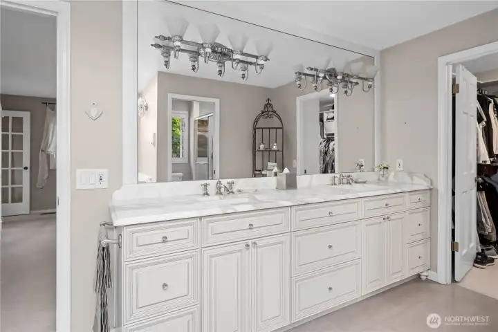 Primary bathroom with dual vanity, heated floors, custom cabinetry and marble countertops.