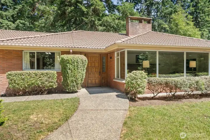 A welcoming brick exterior, tile roof, and expansive picture windows set the stage for this Bridle Trails home, where timeless Northwest character meets the opportunity to customize, modernize, and make the property your own.