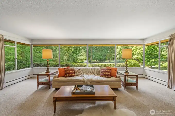 Spacious and filled with natural light, the living room captures the beauty of Bridle Trails with wraparound windows, evergreen outlooks, and room to reimagine the home’s style while preserving its welcoming, estate-like feel.