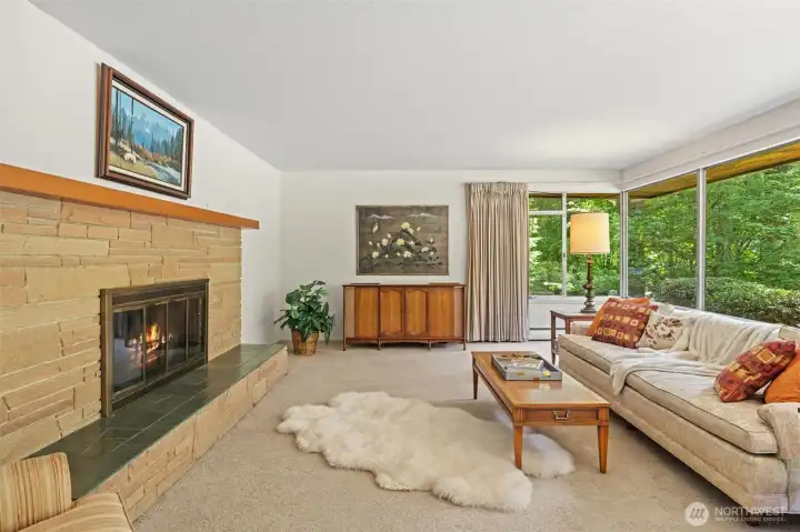 A classic wood-burning fireplace anchors the living room, adding warmth, character, and a cozy gathering place. With generous proportions and natural views, this space offers exceptional potential to refresh, remodel, and make it your own.