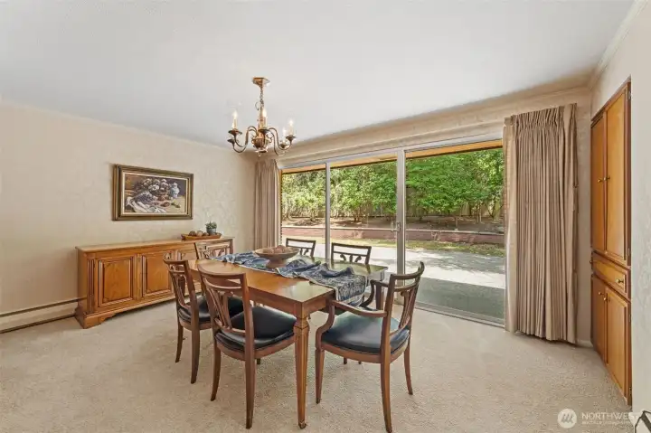 The formal dining room features a large sliding glass door that creates a seamless connection between the indoors and the private backyard patio, making entertaining and everyday living effortless. Enjoy peaceful garden views while hosting dinner parties.